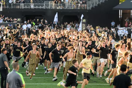 Wake Forest University Demon Deacon fans come together at Allegacy Stadium for the first home football game against Elon University on Thursday, August 31, 2023. Students run across the field as part of the Deacon Dash for first year students.