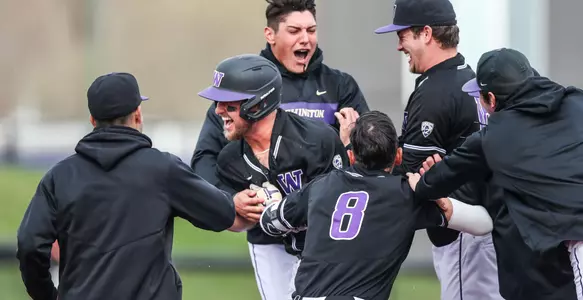 Teammates mob Nick Kahle after his walk-off single sent UW home with a 3-2 win.