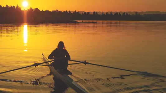 Single scull rower on Lake Washington at sunrise