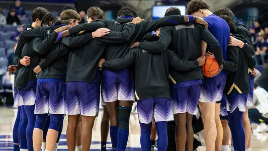 UW men's basketball team huddle during pregame warmups