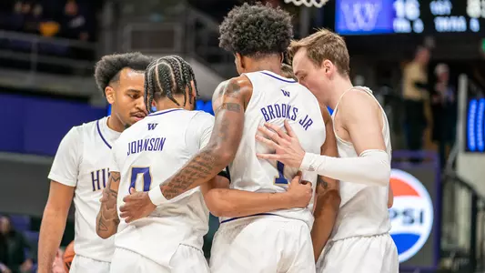 Men's basketball huddles on the court