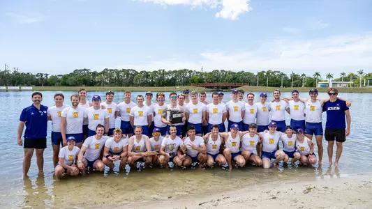 UW men's rowing team with trophies on the beach at 2024 IRA Sarasota Invitational
