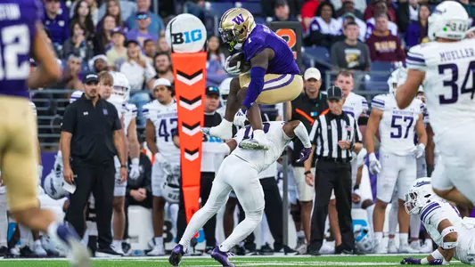 Jonah Coleman hurdles a Northwestern defender