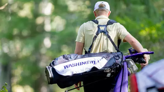 Finn Koelle carries bag during round