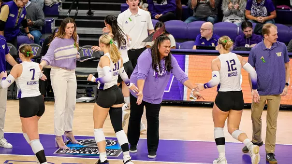 Head Coach Leslie Gabriel giving high-fives to Husky players leaving the court