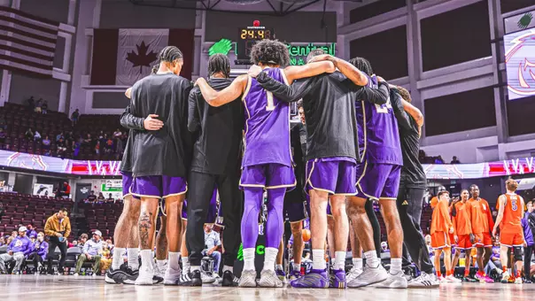 Team huddle pregame before Washington's exhibition at Boise State