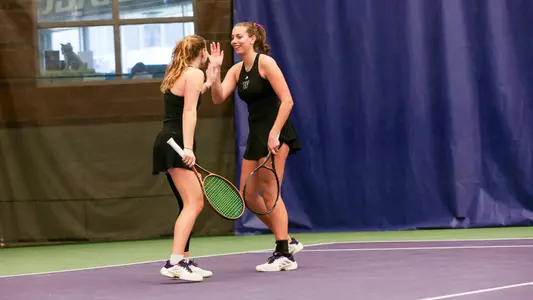Marie Weissheim and Alexia Jacobs high fave during doubles against UCSB