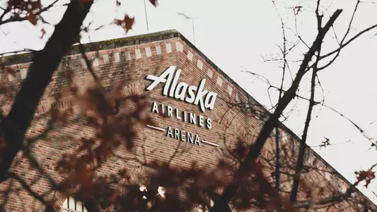 Alaska Airlines Arena logo through the trees