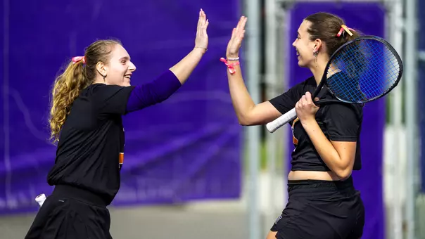 Marie Weissheim and Alexia Jacobs high five during doubles vs Northwestern