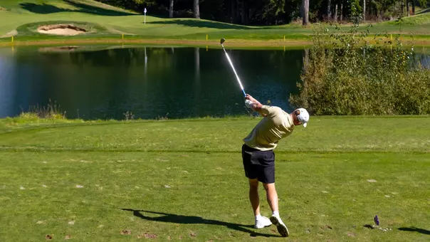 Finn Koelle hits a shot to a par 3 over water