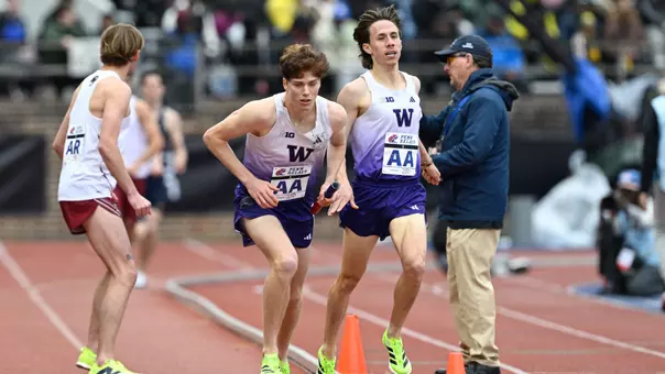 Martin Barco takes the handoff from Reuben Reina at the Penn Relays