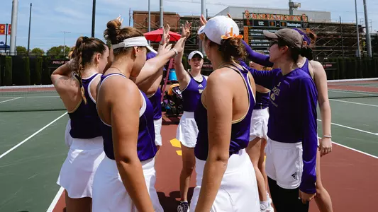 Washington women's tennis team puts dubs up in a huddle prior to their match at USC
