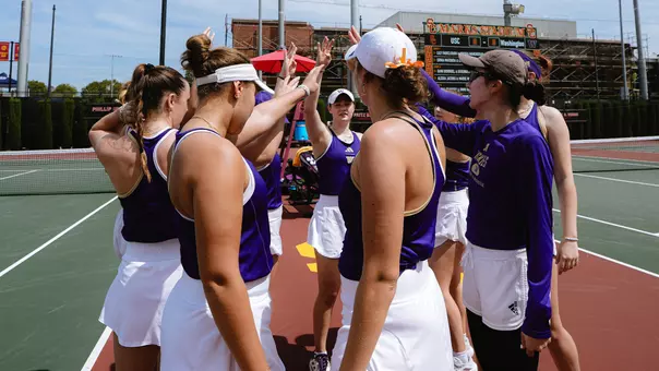 Washington women's tennis team puts dubs up in a huddle prior to their match at USC