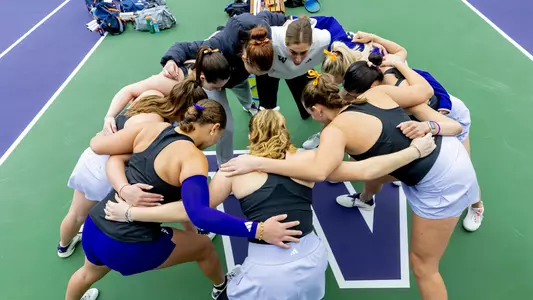 The women's tennis team huddles in a circle prior to its match vs. Illinois
