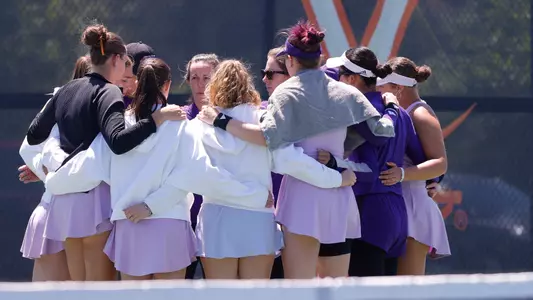 Washington women's tennis huddles as a team following the doubles point at (7) Virginia