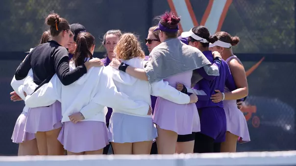 Washington women's tennis huddles as a team following the doubles point at (7) Virginia