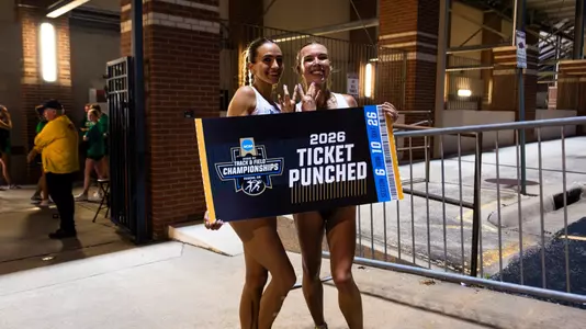Julia David-Smith and Chloe Thomas pose with a Ticket Punched sign at NCAA Prelims