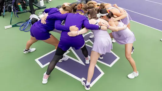Washington women's tennis team huddle around the W