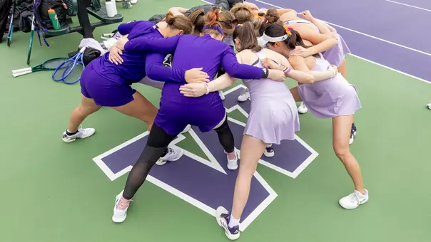 Washington women's tennis team huddle around the W