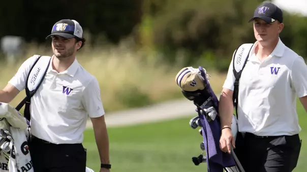 Brock Maulding and Finn Koelle walk with their bags to the green