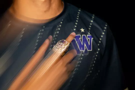 Blurred UW men's soccer national championship ring on player's finger