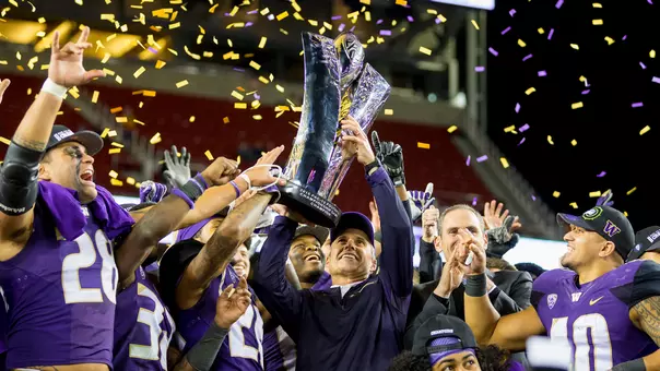 Chris Petersen holds the 2016 Pac-12 Championship trophy following the win over Colorado