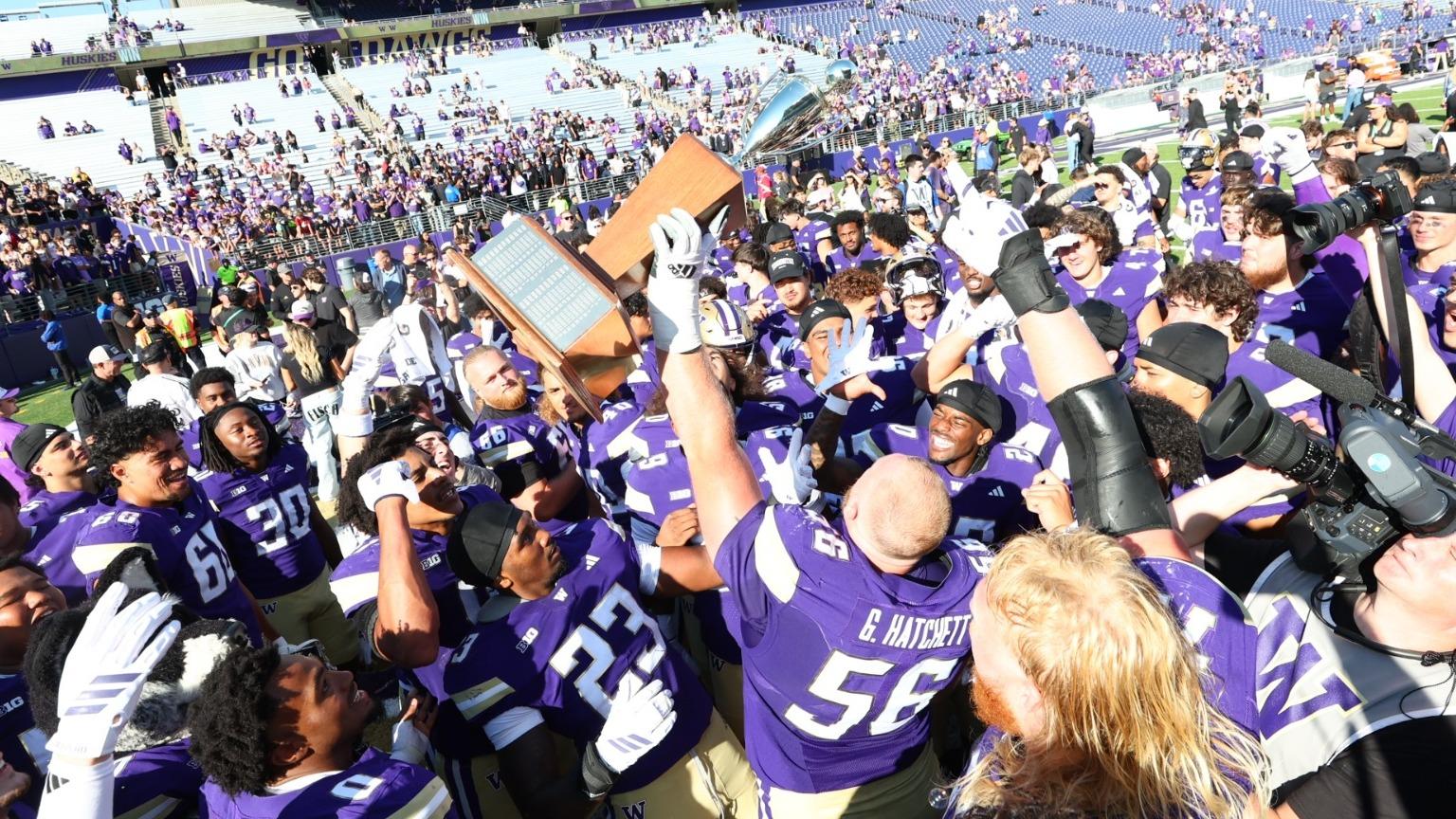 UW football hoisting Boeing Apple Cup trophy