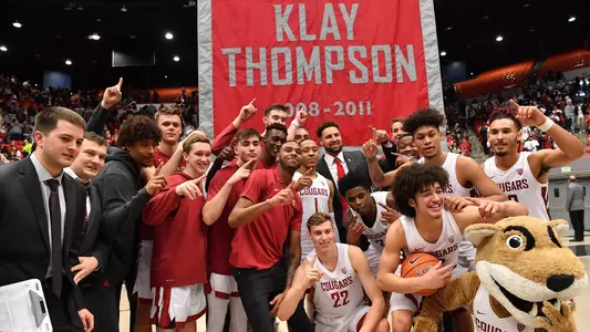 MBB celebrates their win over OSU with Klay Thompson in front of his #1 Banner