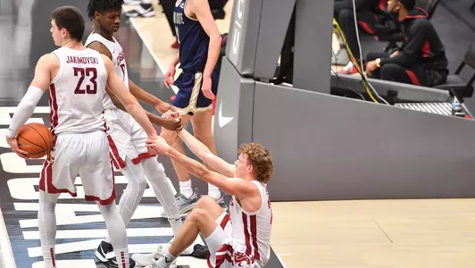Efe Abogidi and Andrej Jakimovski help Ryan Rapp off the floor
