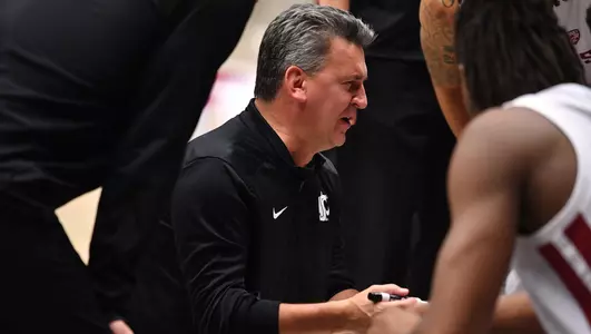 Coach Kyle Smith talking to the team in the huddle during a timeout