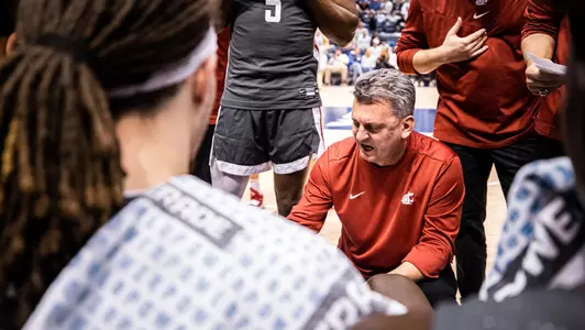 Coach Smith talking to the team in the huddle during a timeout at BYU