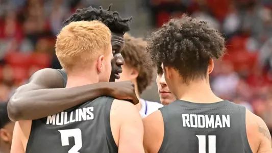 Mouhamed Gueye huddles with Jabe Mullins and DJ Rodman during the win against Washington