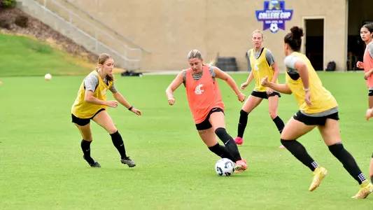 Elliotte Kortus dribbles near defending teammates during a fall training session