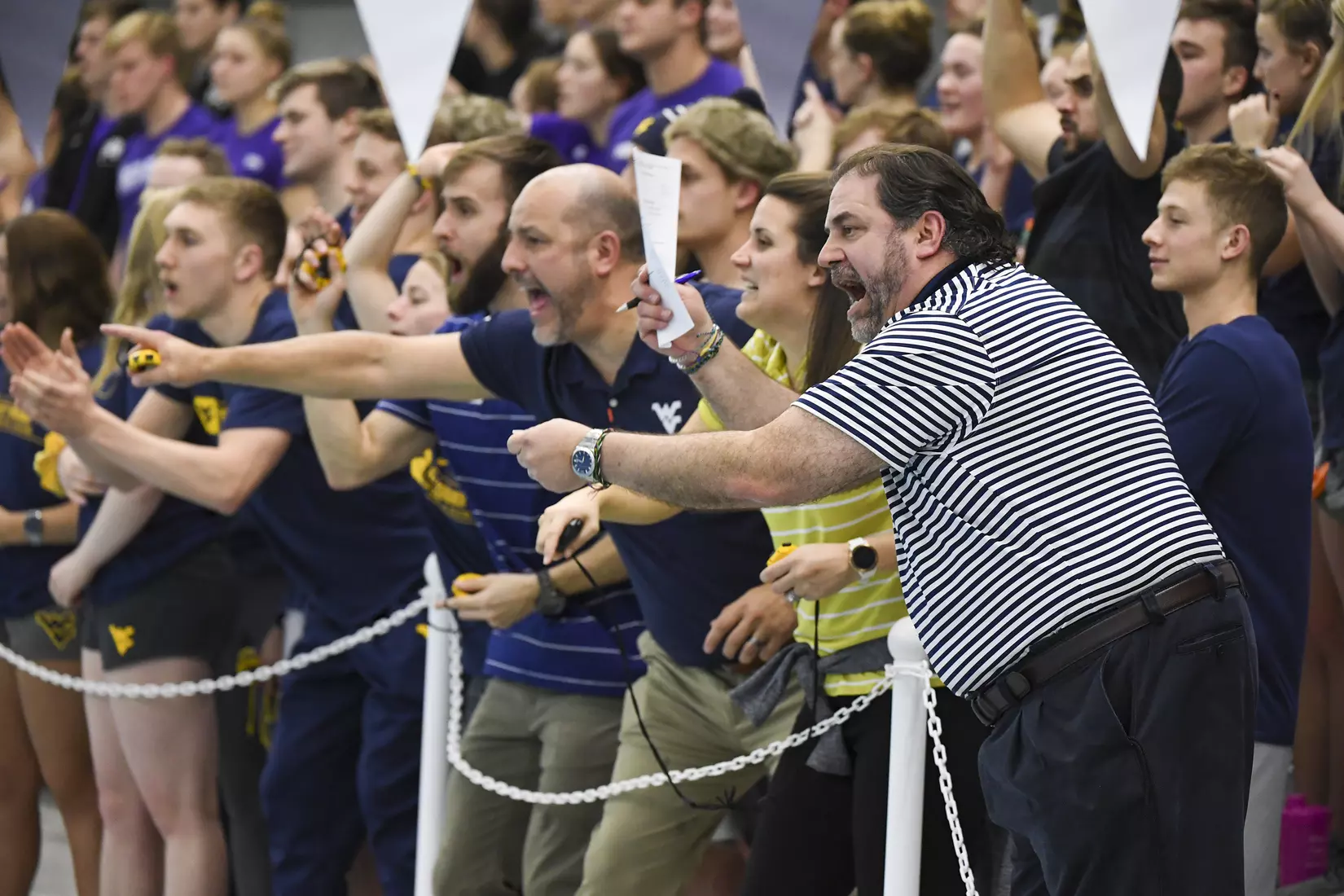 Head coach Vic Riggs cheers on his swimmers.