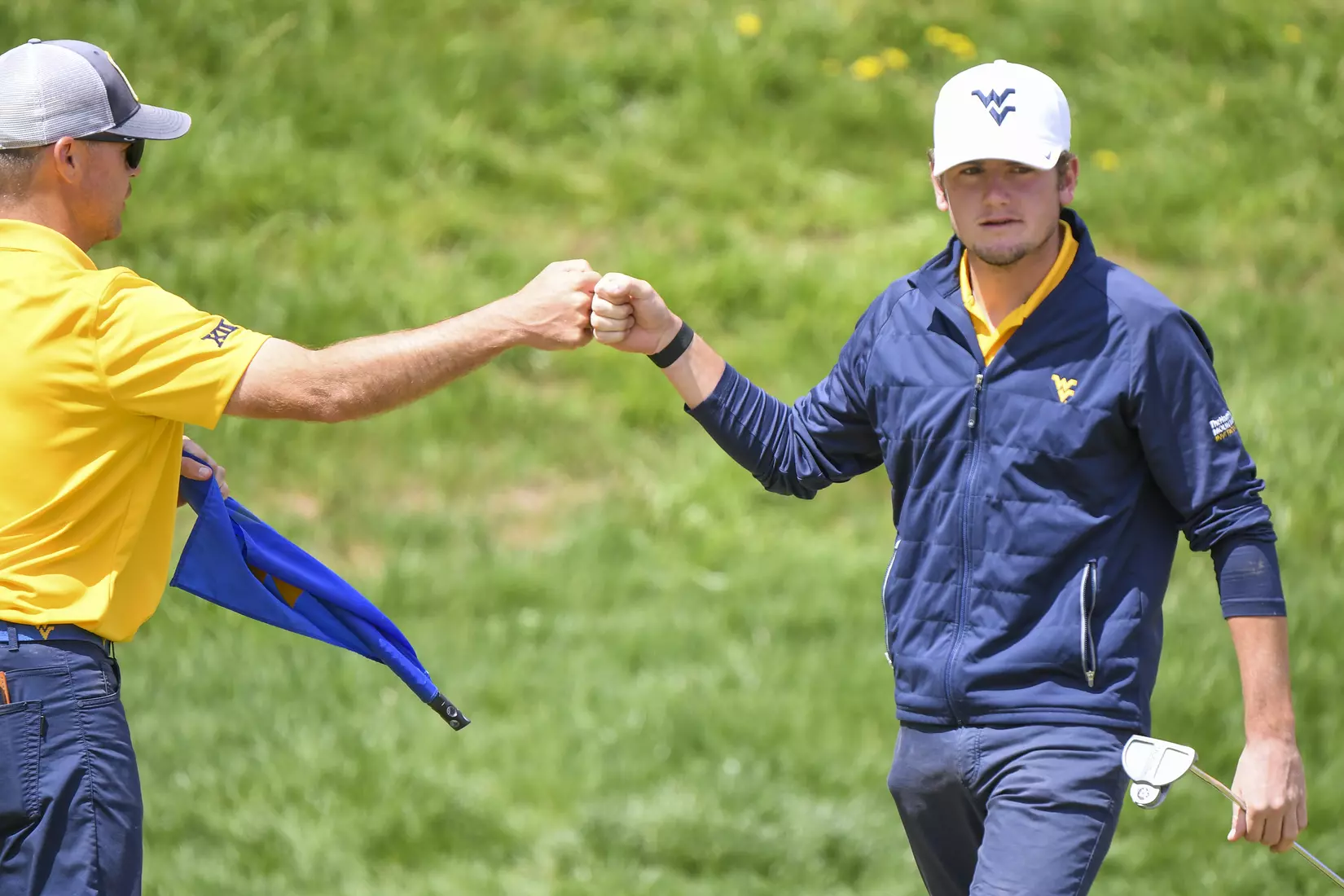 Logan Perkins fist bumps head coach Sean Covich after a birdie on six.