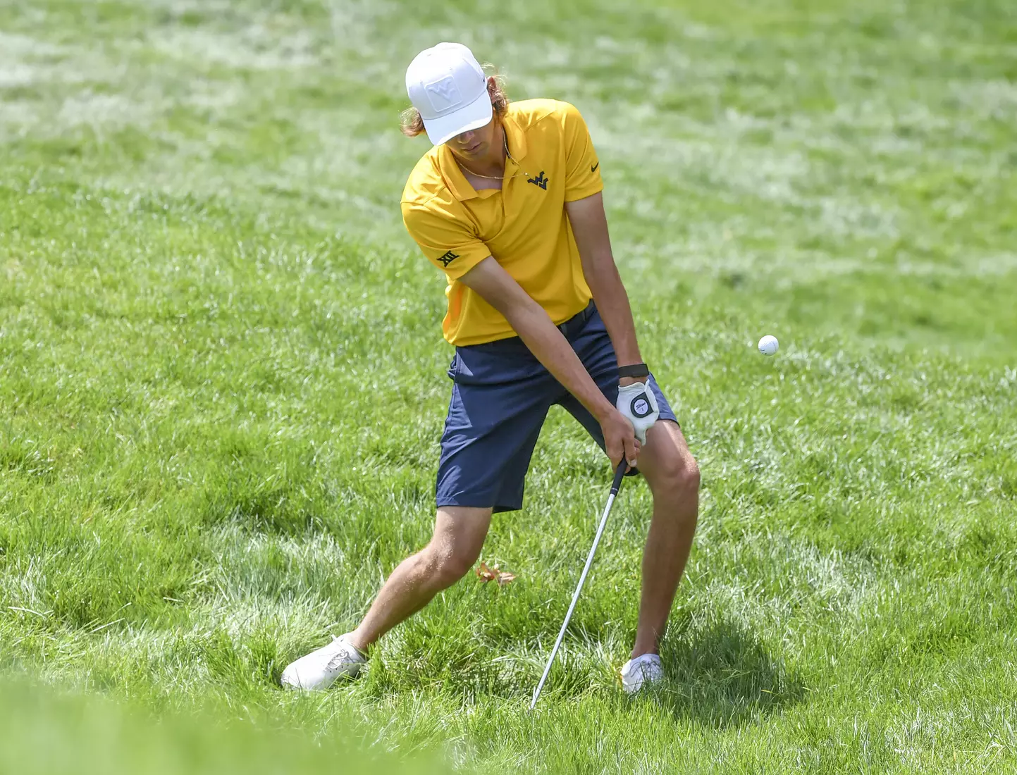 Individual medalist Mark Goetz chips out of a grass bunker.