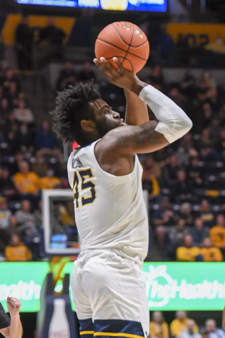 Emmitt Matthews and Oscar Tshiebwe pose with a fan for a selfie.