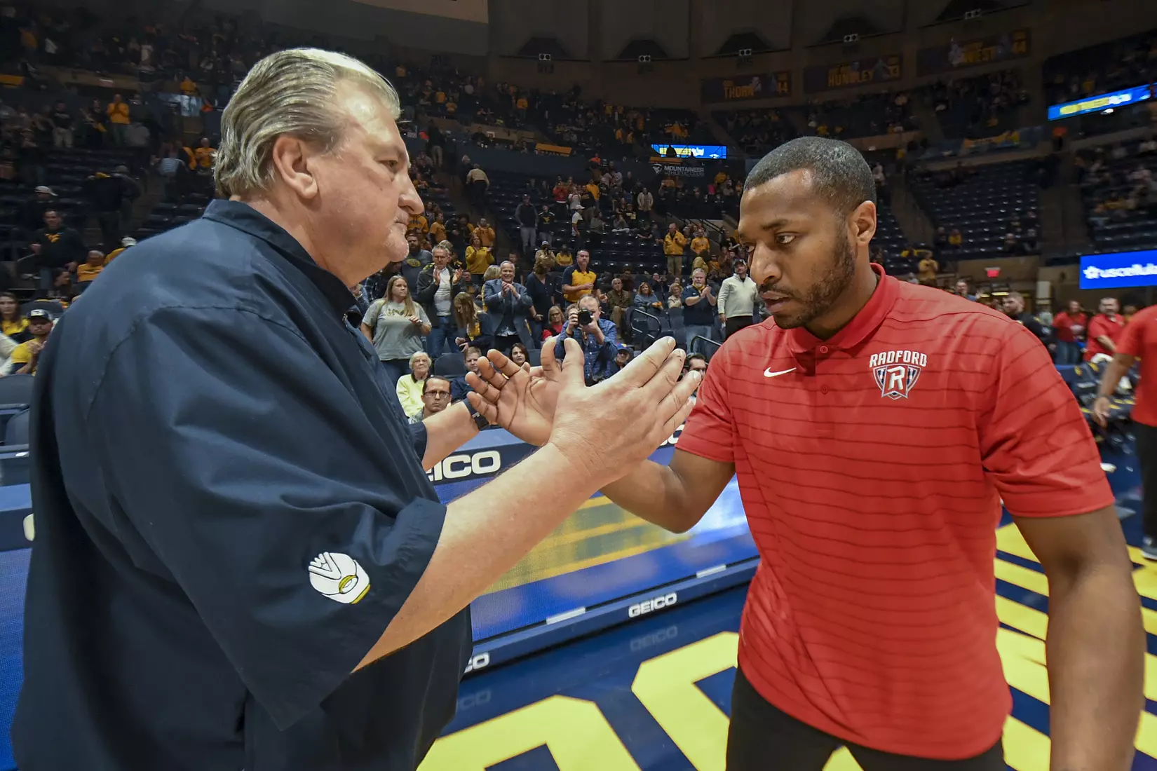 Head coaches Bob Huggins and Darris Nichols shake hands after the game.