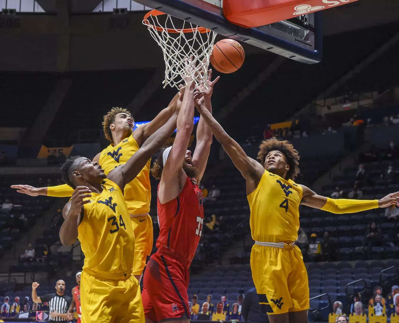 Oscar Tshiewbe, Emmitt Matthews Jr. and Miles McBride team-up for a rebound.