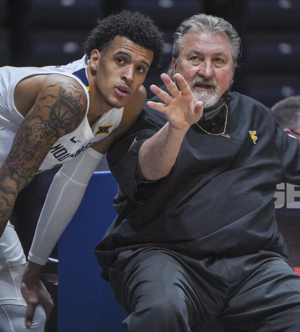Bob Huggins talks with Jalen Bridges on the sidelines.