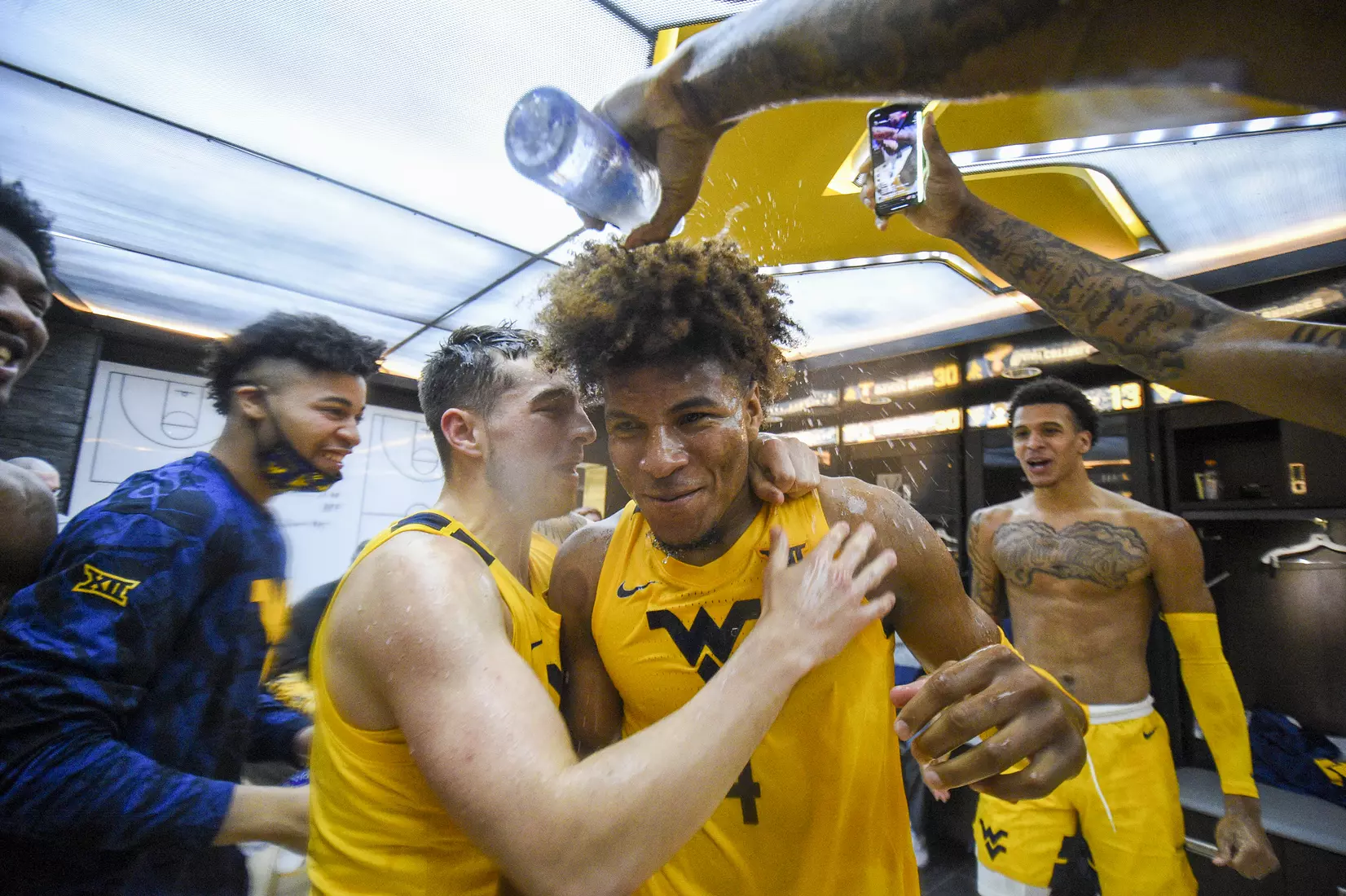 Miles McBride enjoys his "water serenade" as he enters the locker room.