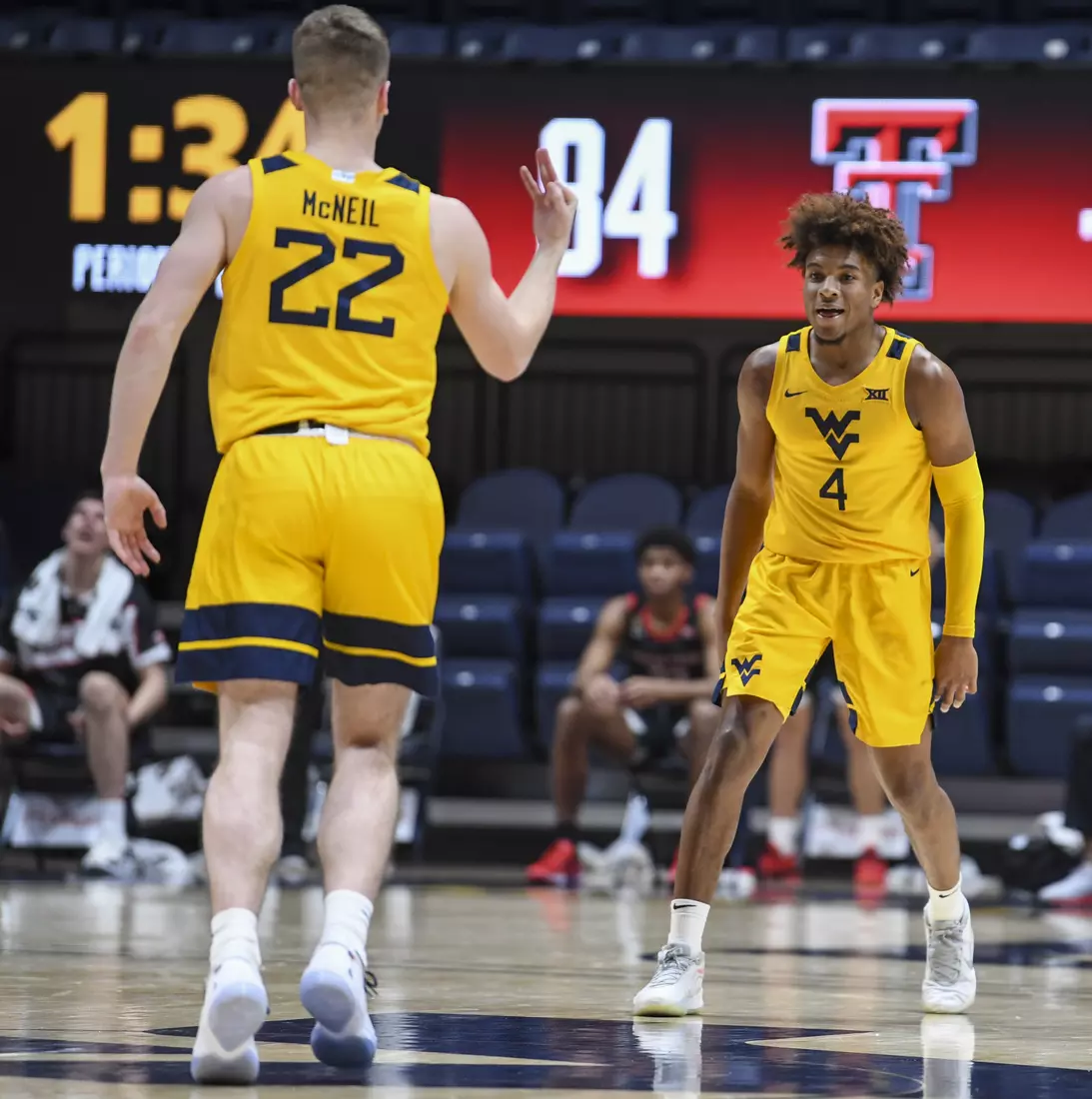 Sean McNeil congratulates Miles McBride on a three-pointer.