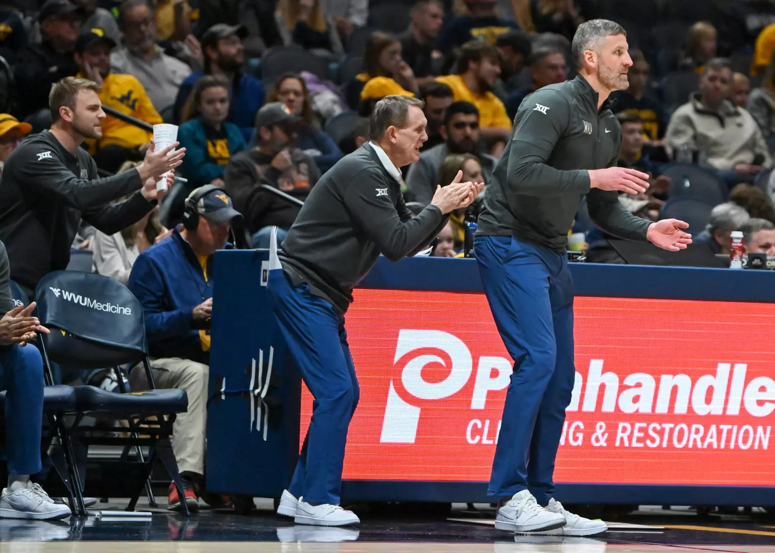 Head coach Josh Eilert and his staff cheer on the Mountaineers.