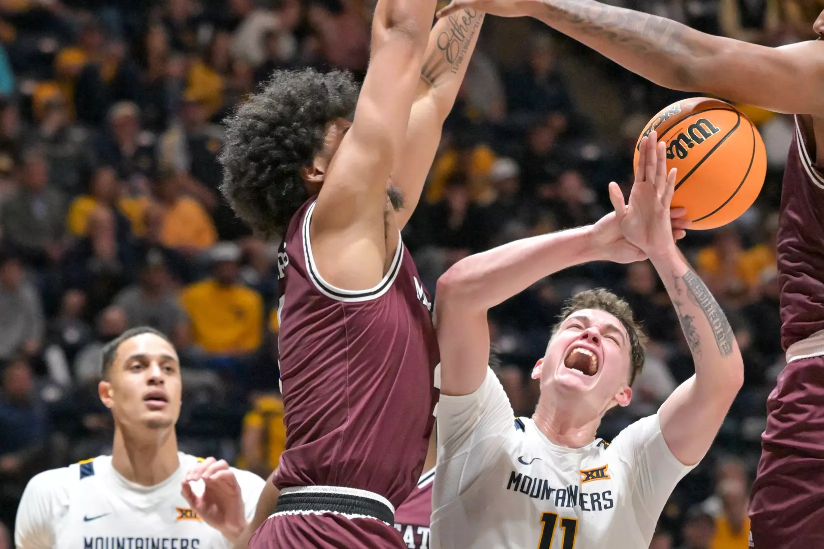 Quinn Slazinski is fouled while shooting.
