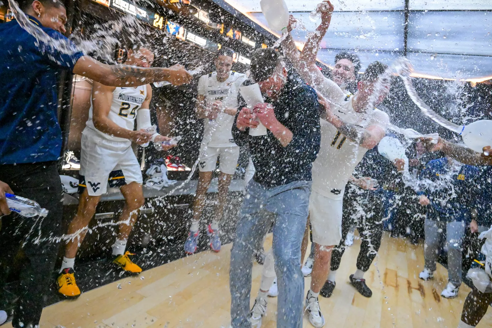 Head coach Josh Eilert is congratulated by his team in the lockerroom for his first ever win.