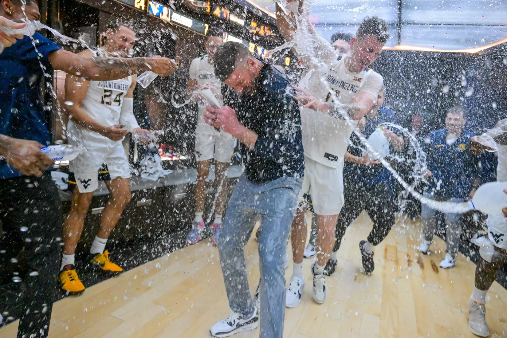 Head coach Josh Eilert is congratulated by his team on the court for his first ever win.
