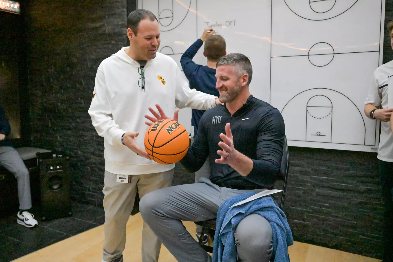 Head coach Josh Eilert is awarded a game ball for his first ever win by Director of Athletics Wren Baker.