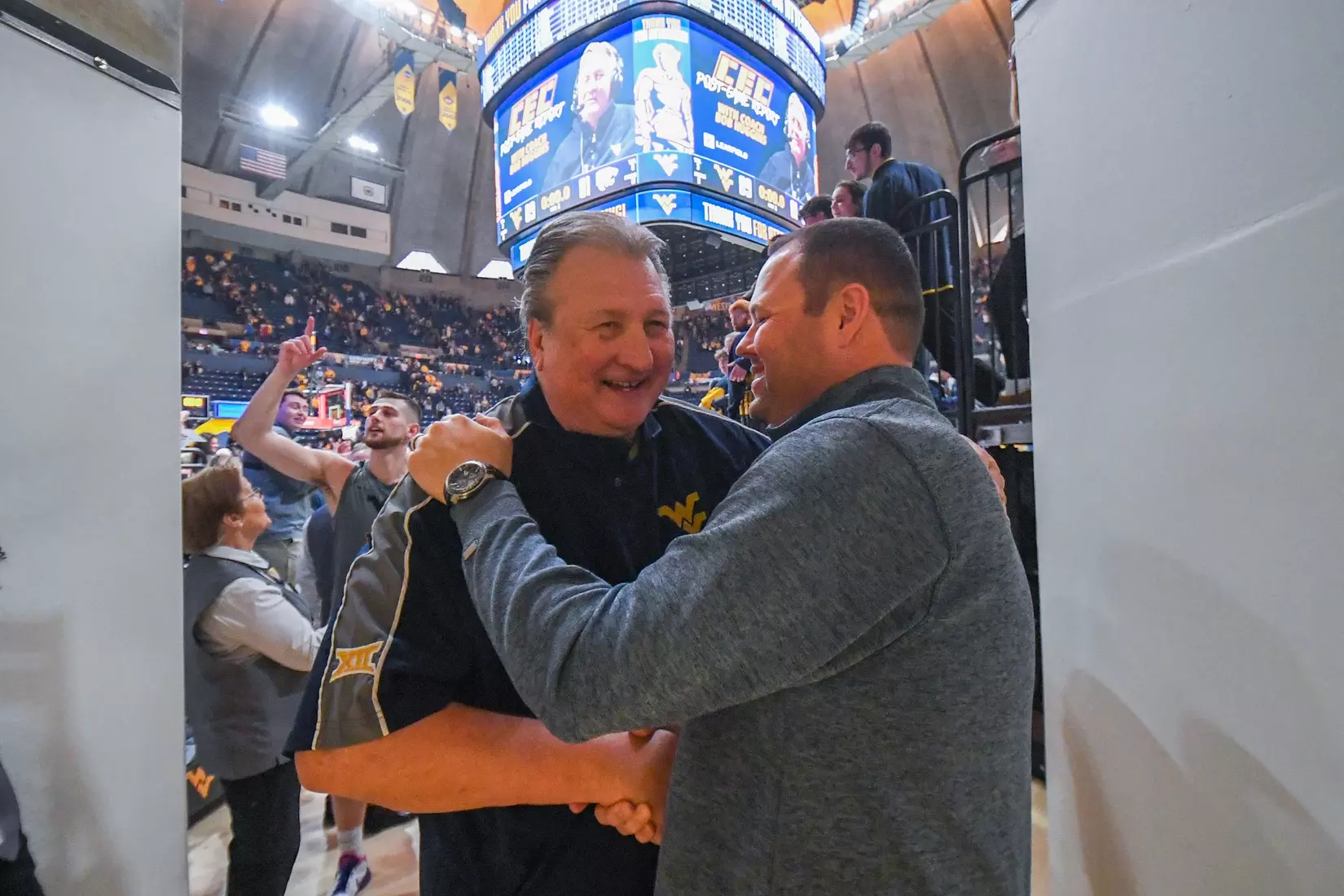 Bob Huggins gets a congratulatory hug from AD Wren Baker.