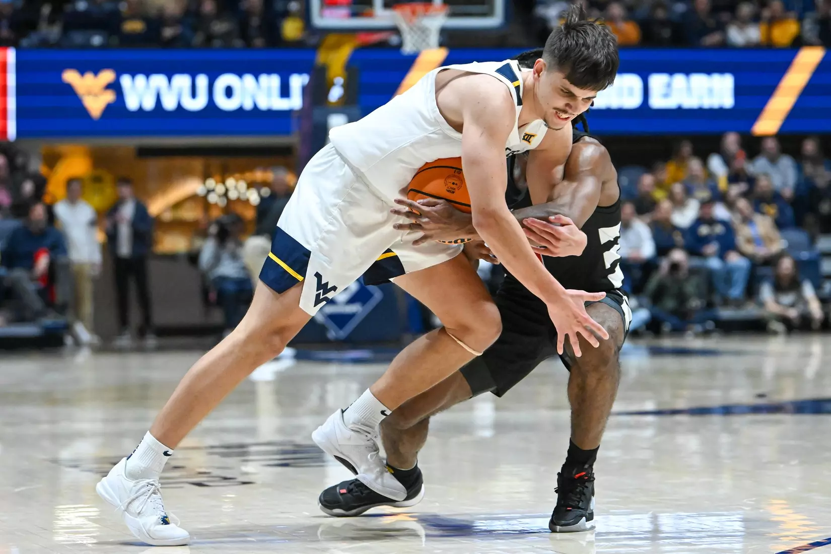 Kerr Kriisa is tied-up by a defender on a drive to the basket.