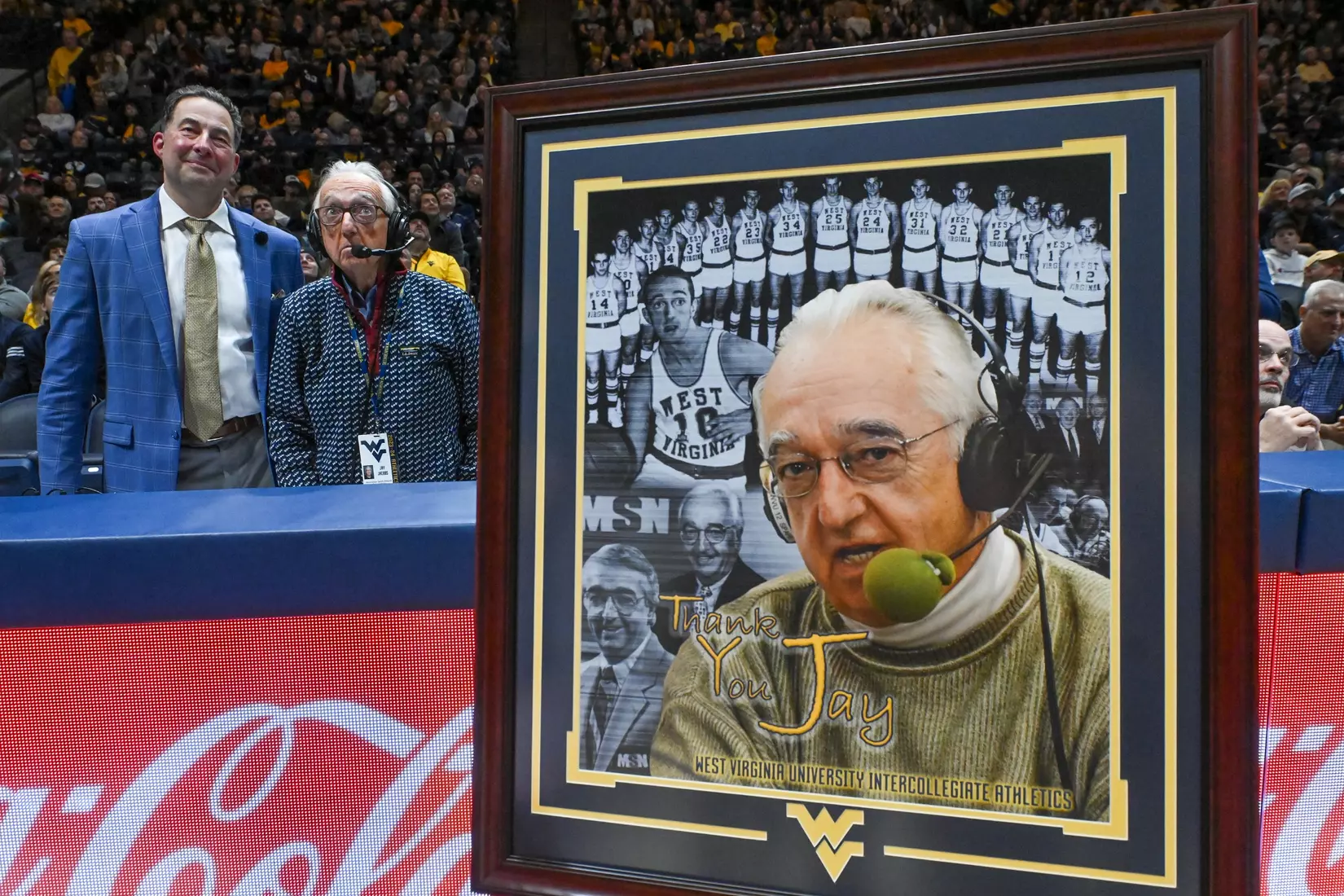 Tony Caridi and Jay Jacobs watch a tribute video during a timeout.